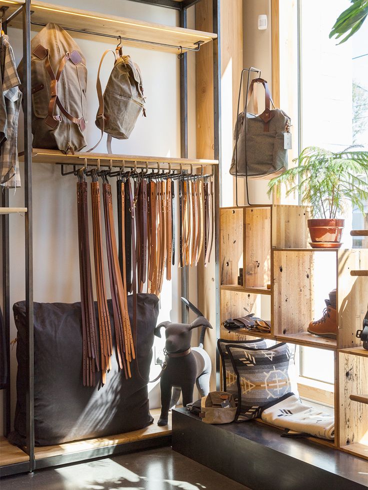 a room filled with lots of purses and bags hanging on the wall next to a window