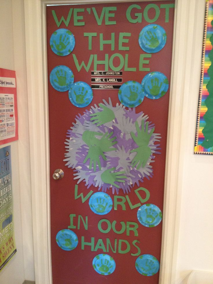 a door decorated with handprints and the words we've got the whole world in our hands