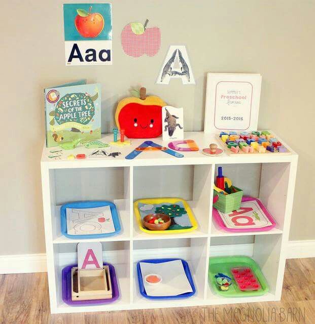 a white book shelf filled with books and toys