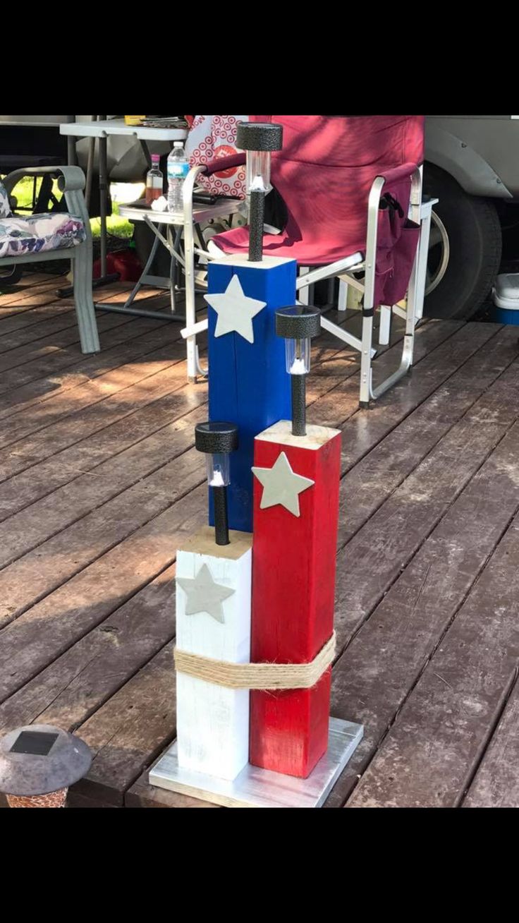 an outdoor sculpture made out of wooden blocks with red, white and blue stars on them