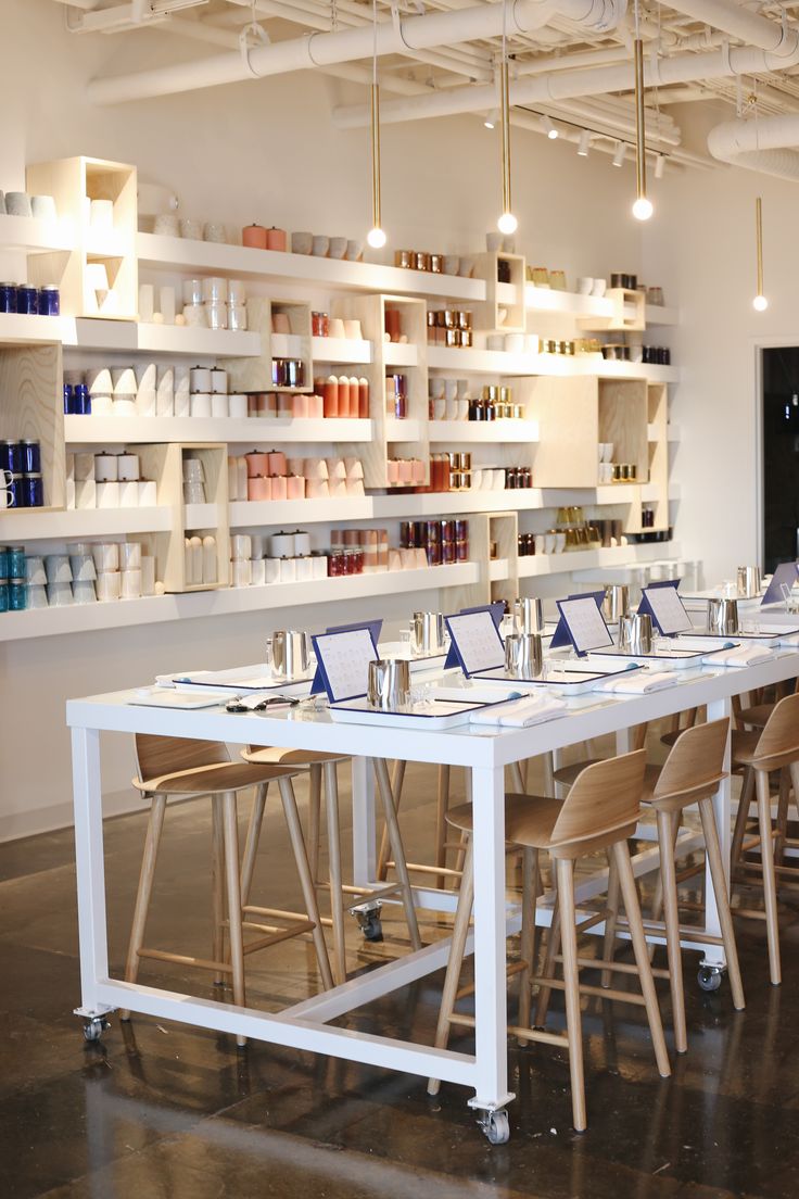 a long table with many chairs in front of it and shelves on the wall behind it