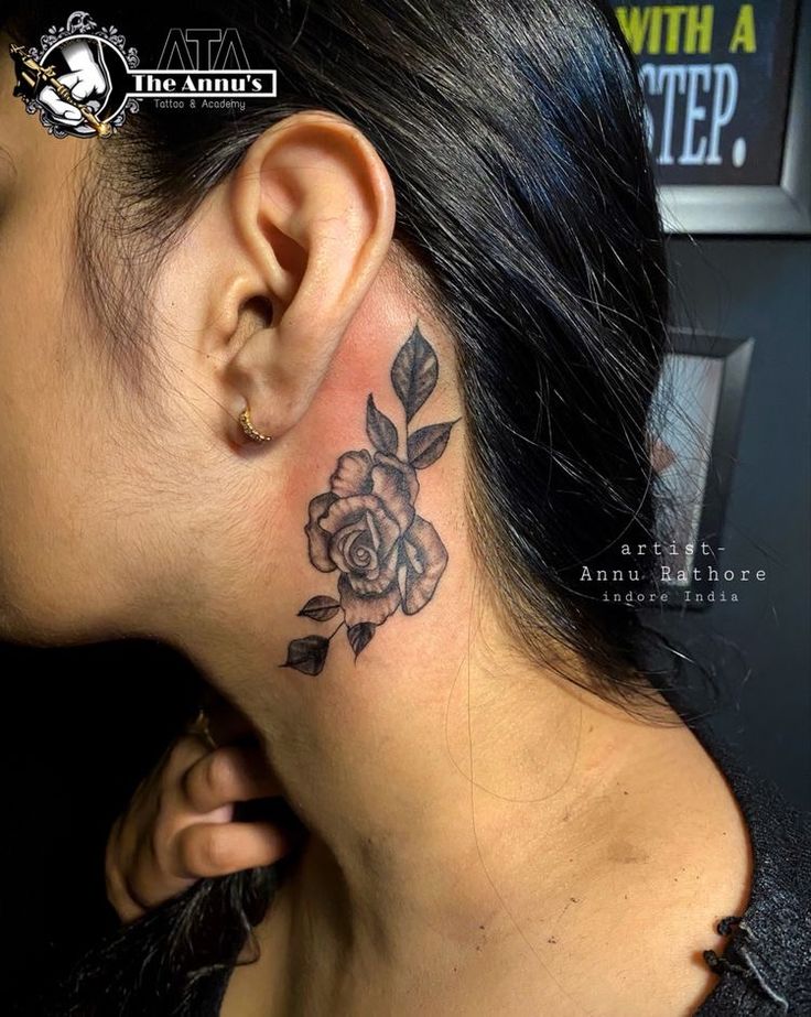 a woman with a black rose tattoo on her left side behind the ear and behind the ear