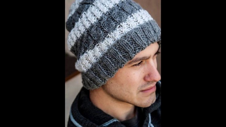 a man wearing a gray and white striped knitted hat with a scarf around his neck