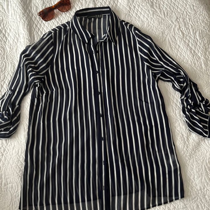 Nautical Style Long Sleeved Striped Shear Shirt. Say That 10 Times! Collared Shirt With Tabs To Button Up Sleeved To A Shorter Length. Cute With White Cut Off Jeans For Hot Summer Nights. Could Be Worn As A Swimsuit Coverup No Tags Never Worn Casual Striped Blouse For Work, Chic Striped Shirt For Beach, Striped Collared Blouse For Beach, Striped Collared Blouse For The Beach, Navy Collared Blouse For Summer, Classic Long Sleeve Blouse For The Beach, Casual Navy Button-up Blouse, Navy Long Sleeve Blouse For Summer, Navy Long Sleeve Summer Blouse