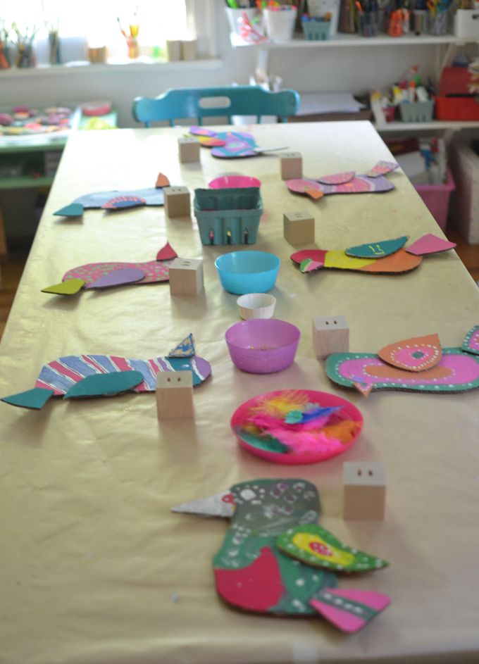 the table is covered with paper plates and other crafting supplies for children to make