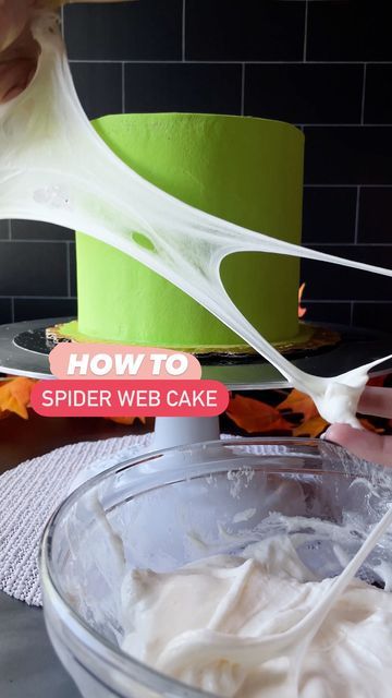 someone is adding white icing to a cake in a bowl on the counter top