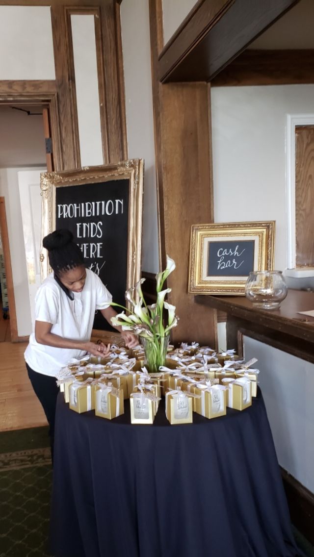 a woman standing in front of a table filled with jars