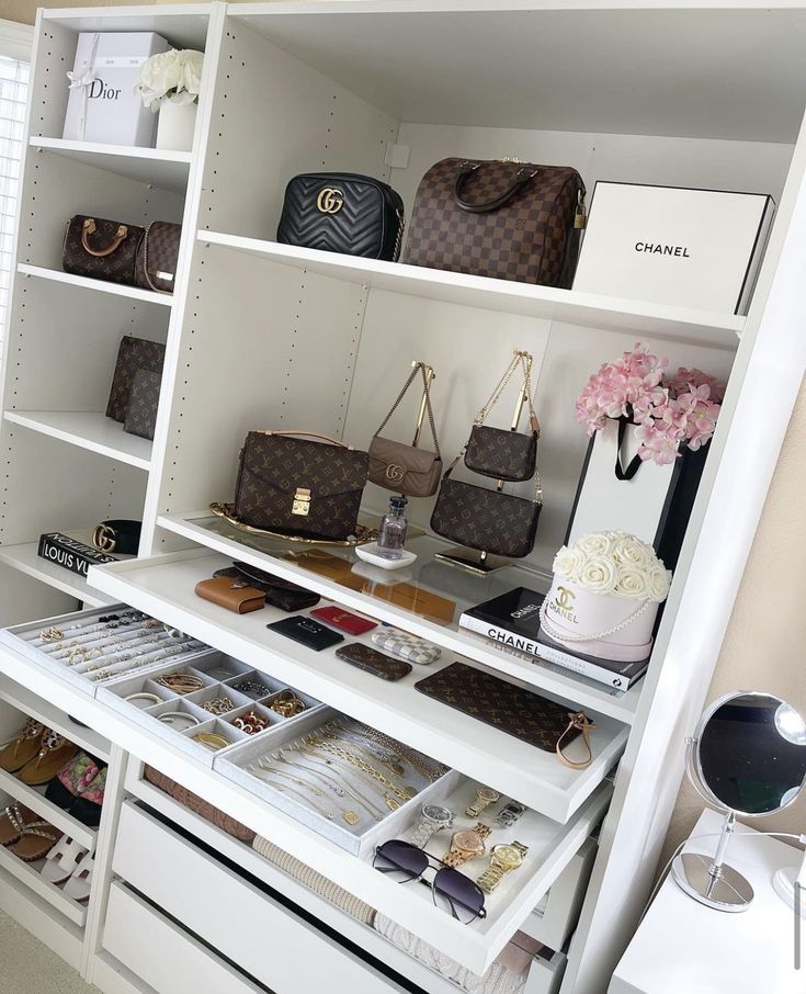 a closet with many purses and handbags on shelves, including one that is open