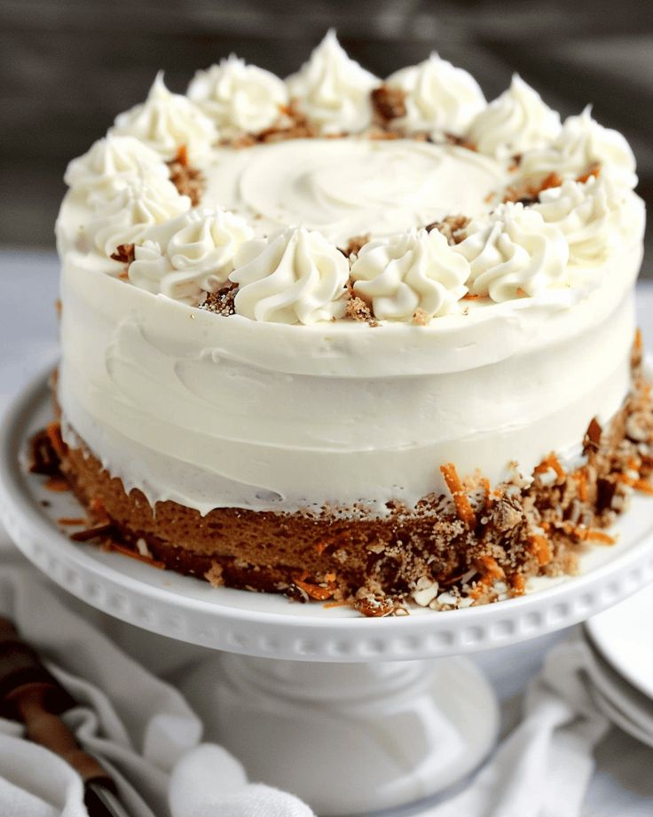 a cake with white frosting and sprinkles sitting on top of a plate