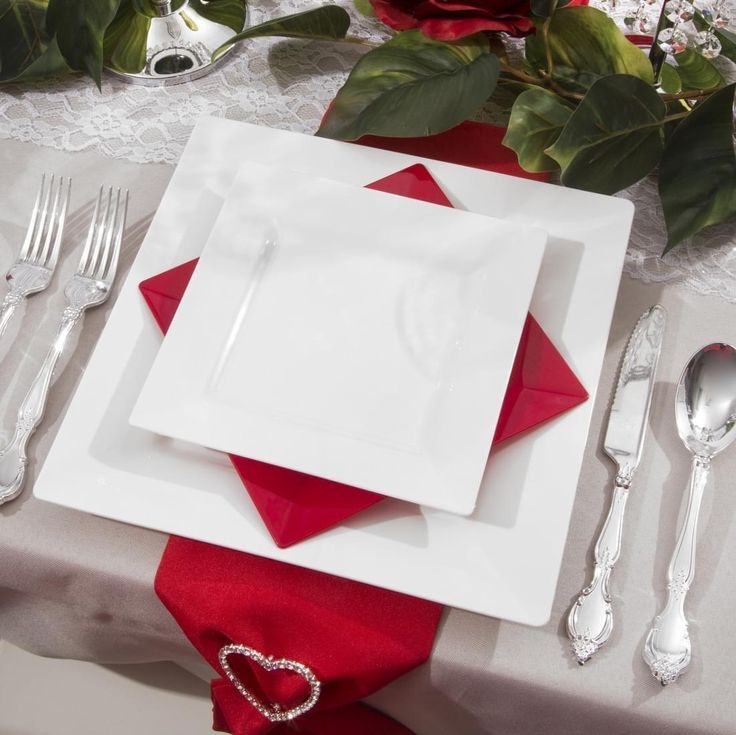 a place setting with red napkins and silverware