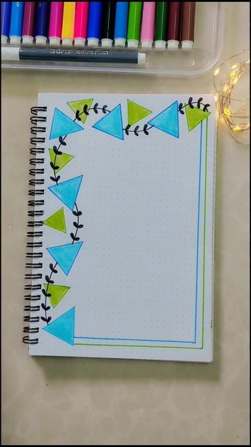 an open notebook with markers and crayons next to it