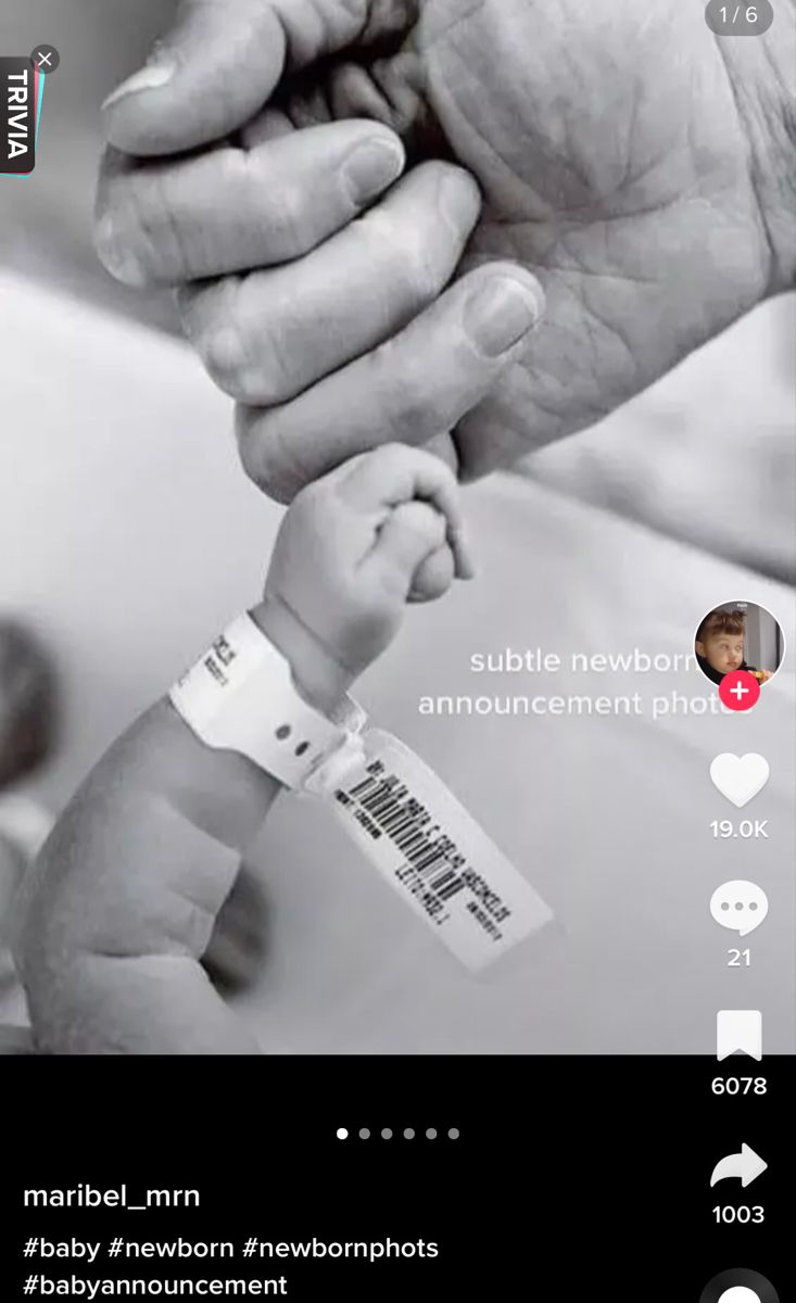 a baby holding the hand of an older person's hand with barcodes on it