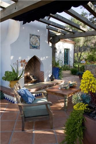 an outdoor patio with chairs, table and fireplace