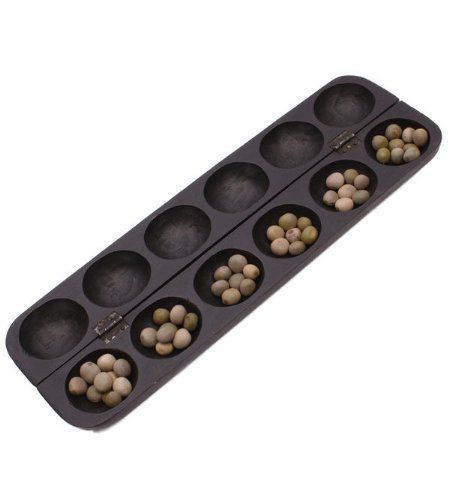 an empty muffin pan filled with nuts on a white background