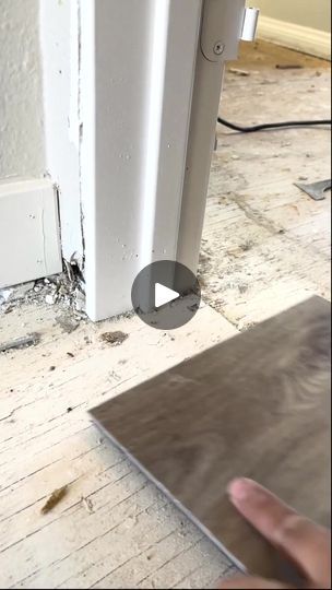 a hand is pointing at the corner of a room that has been stripped off and damaged