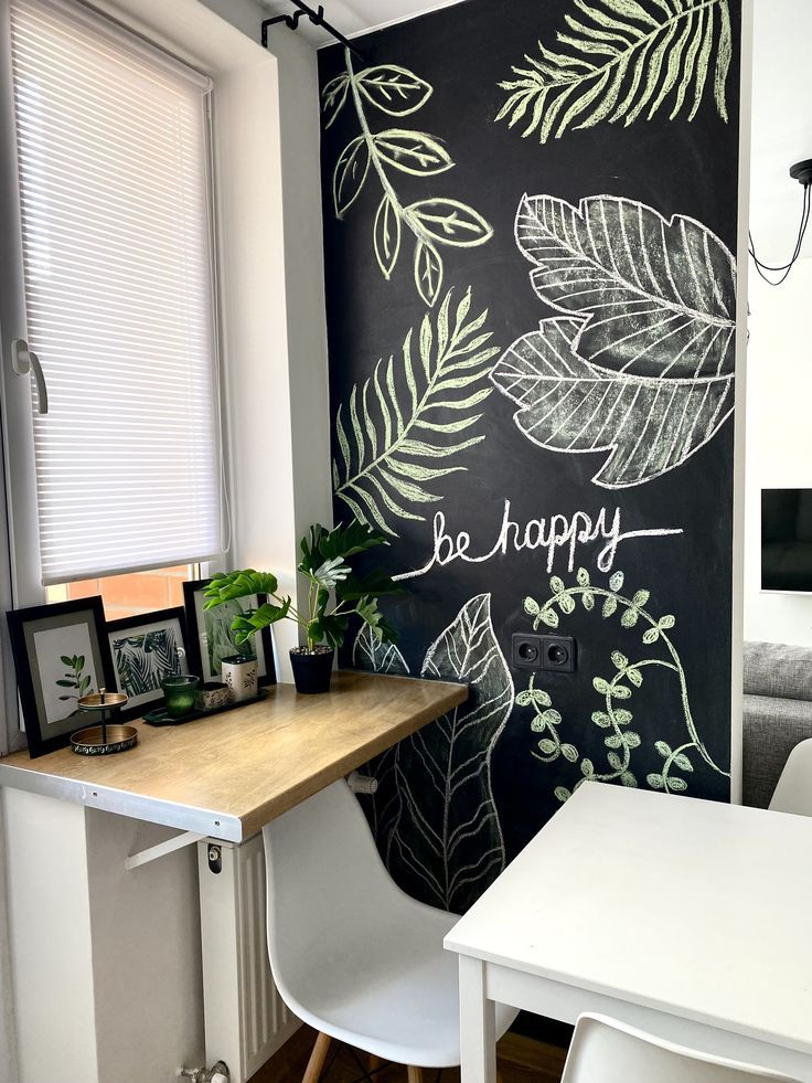 a chalkboard wall with leaves painted on it