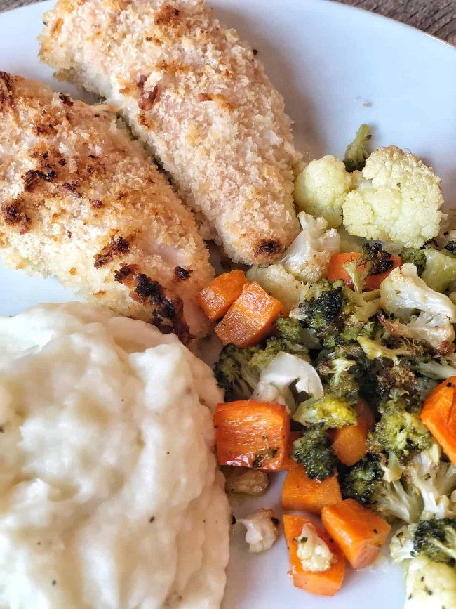 a white plate topped with chicken, broccoli and carrots next to mashed potatoes