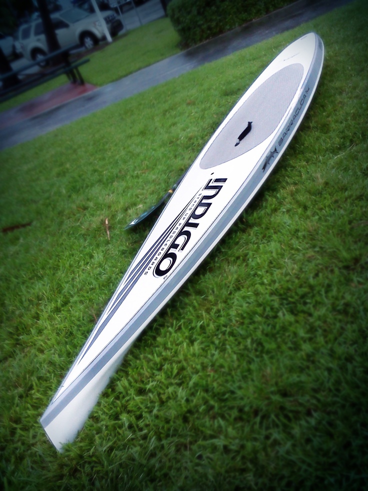 a white surfboard laying on the grass