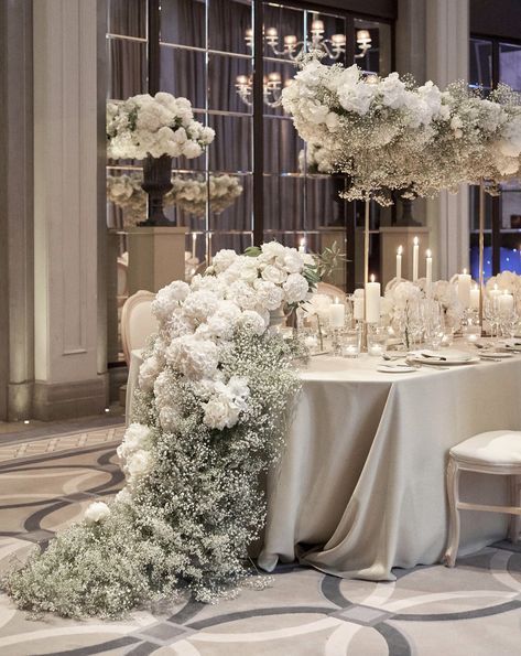 the table is set with white flowers and candles for an elegant wedding reception at the four seasons hotel