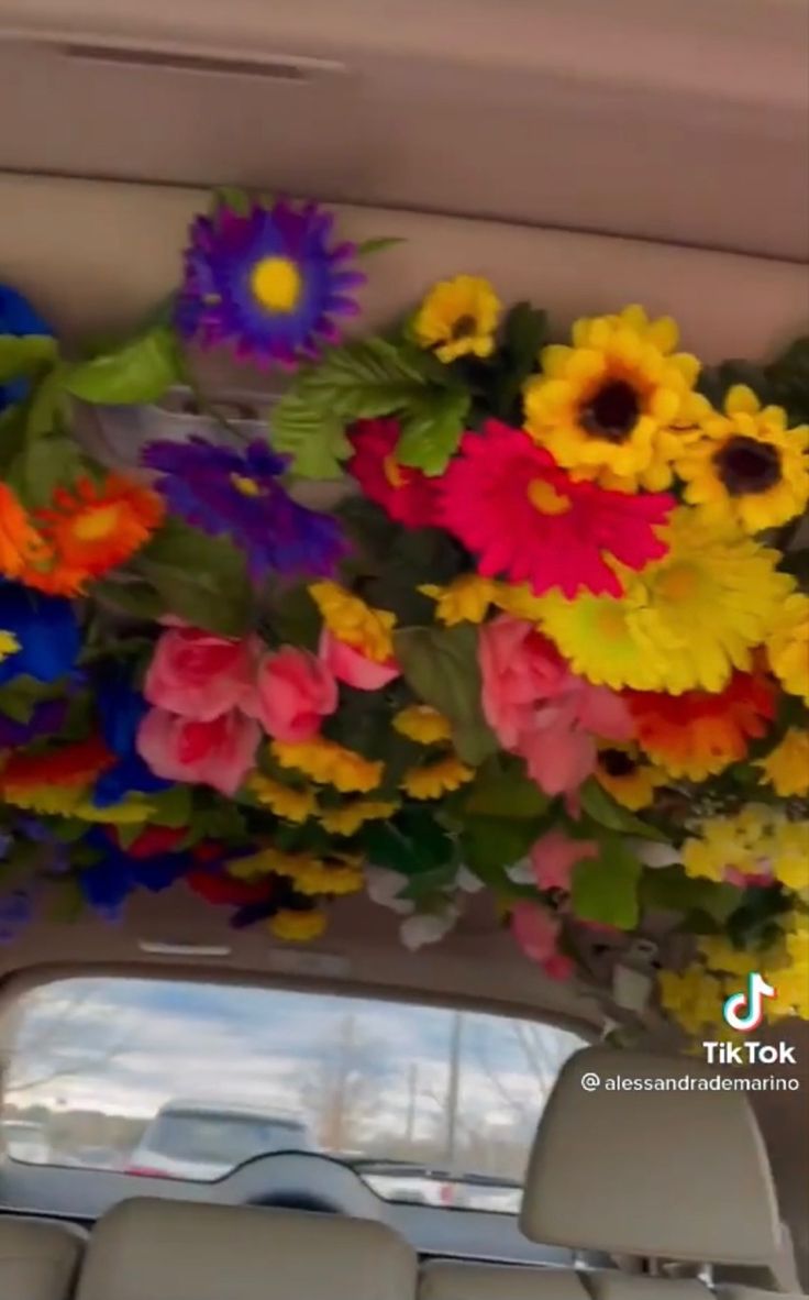 colorful flowers are hanging from the ceiling in a car