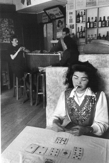 a woman sitting at a table with cards in front of her