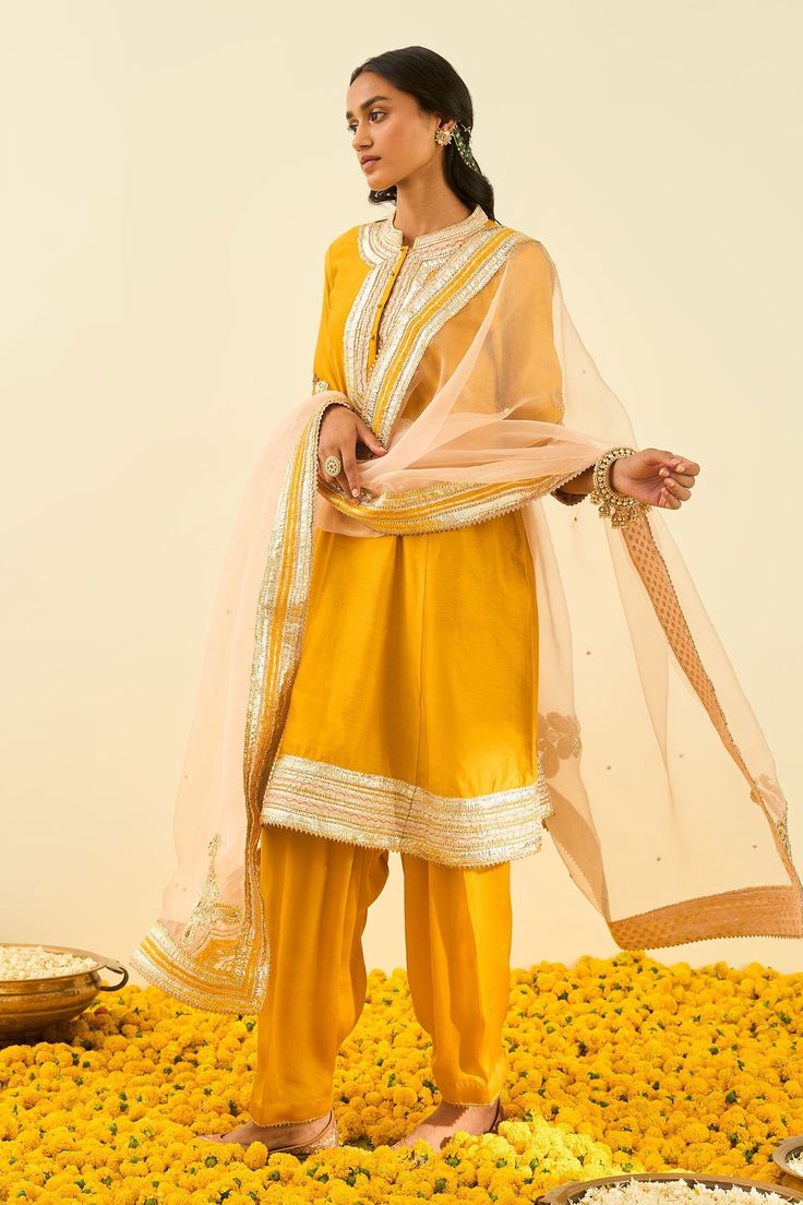 Glaze mustard kurta with gota patti work and highlighted with basra moti. Paired with salwar and rose pink dupatta.
Component: 3
Pattern: Embroidered
Type Of Work: Gota and Bead Work
Neckline: Mandarin
Sleeve Type: Long Sleeves
Fabric: Kurta - Silk Chanderi; Salwar - Bamberg Satin; Dupatta - Silk Organza
Color: Yellow
Other Details: 
Gota and bead work
Embroidered dupatta
Occasion: Wedding,Mehendi - Aza Fashions Gota Patti Embroidery, Yellow Kurta, Indian Fashion Designers, Pernia Pop Up Shop, Silk Organza, Kurta Set, Mandarin Collar, Set For Women, Festival Wear