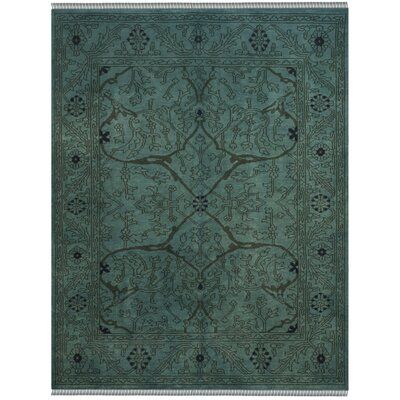 a green rug with an intricate design on it