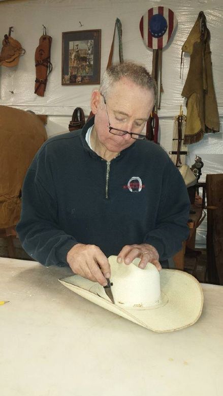 an older man is working on a hat