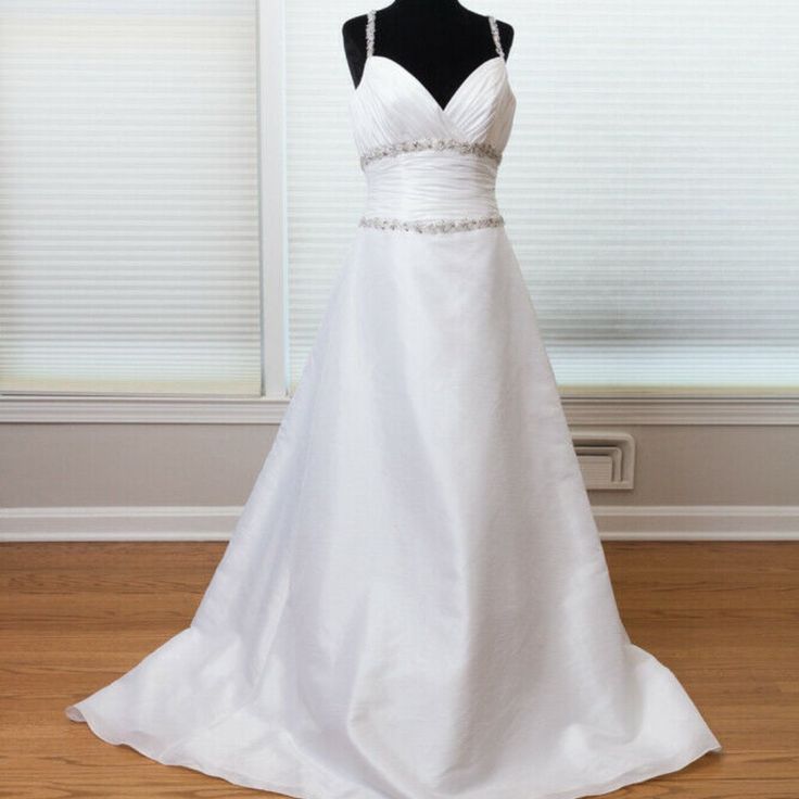 a white wedding dress on display in front of a window