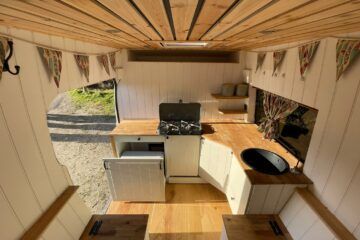 an aerial view of a kitchen and living room in a tiny house with wood flooring