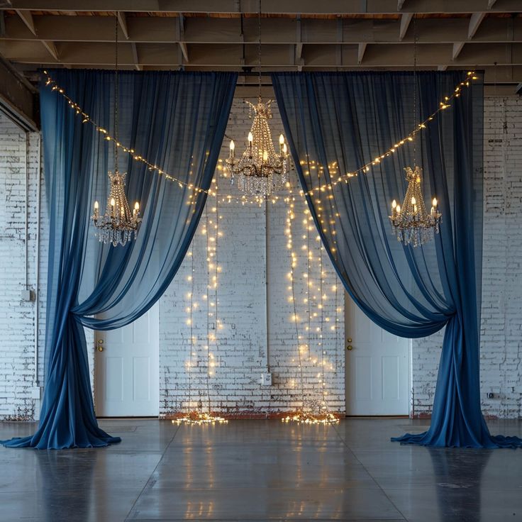 an empty room with blue drapes and chandeliers hanging from it's ceiling