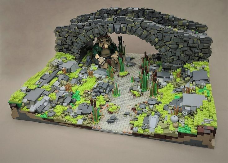 a lego model of a stone bridge with people and animals in the middle of it