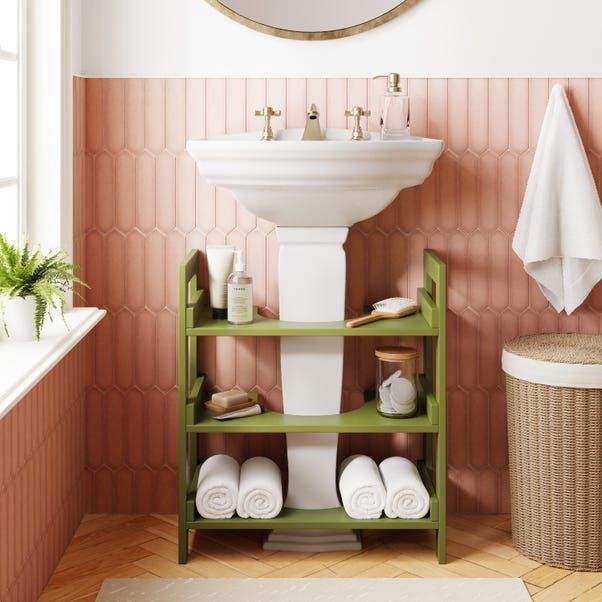 a bathroom with pink and white wallpaper, green shelving unit, sink and mirror