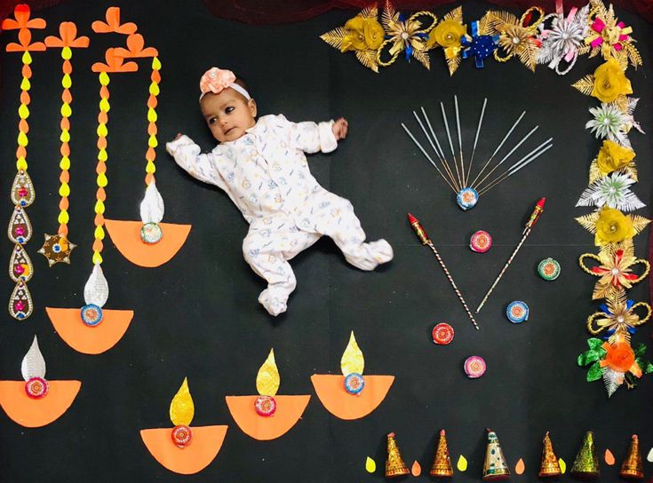 a baby laying on top of a black board surrounded by various decorations and pinstripes