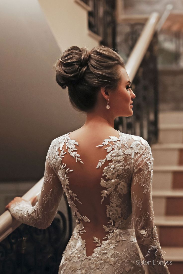 the back of a woman's wedding dress with long sleeves