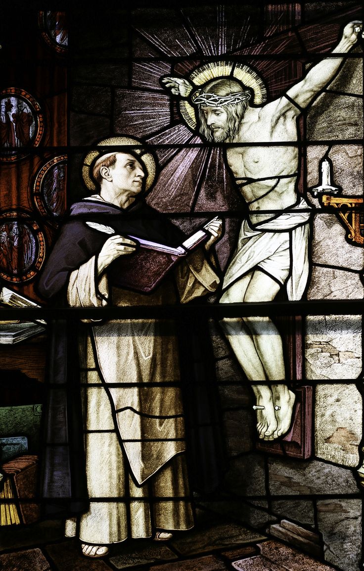 a stained glass window depicting the crucifix with jesus and mary holding an open book