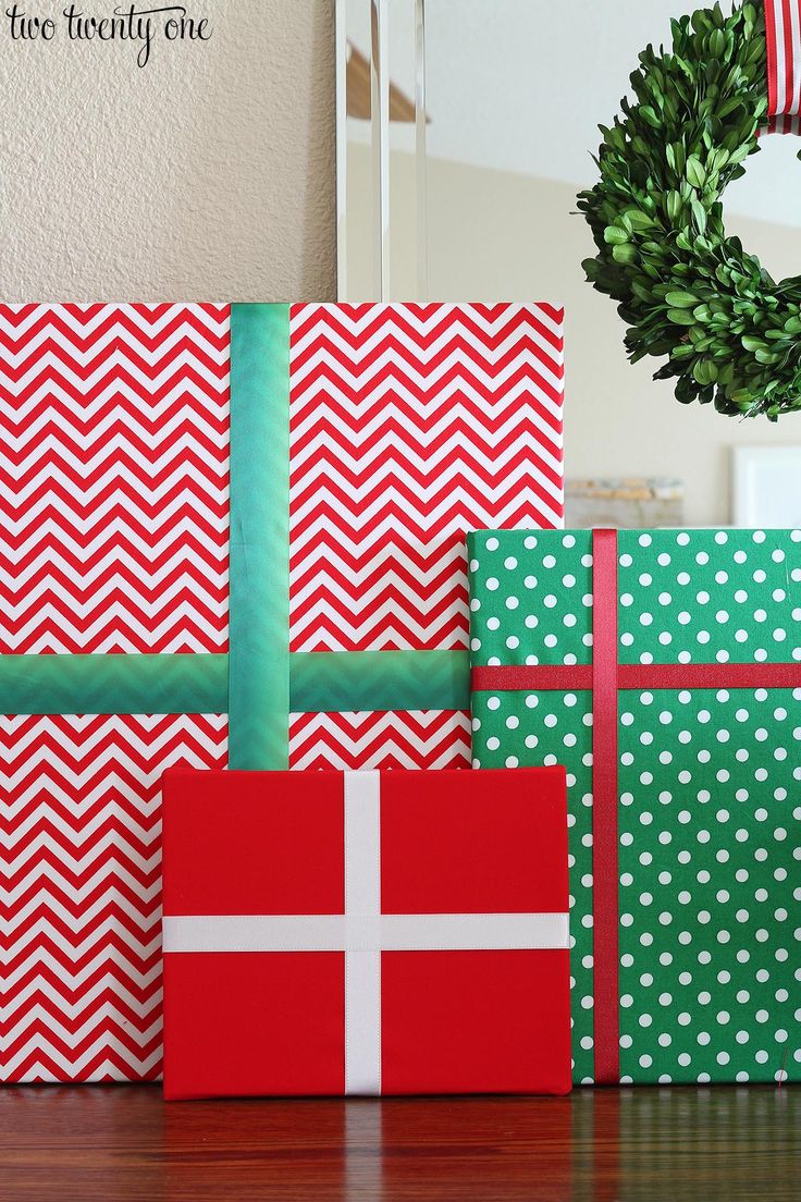 christmas presents wrapped in red, green and white paper with a wreath hanging on the wall