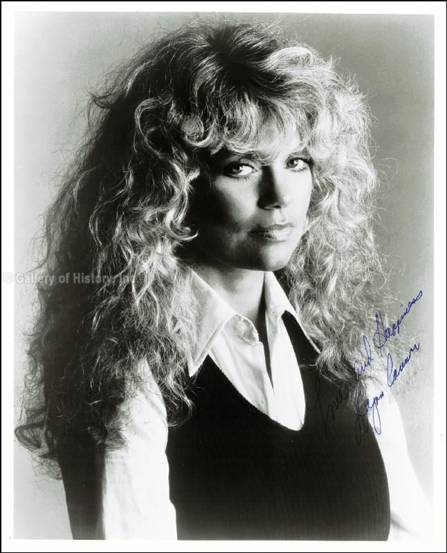 black and white photograph of a woman with long curly hair wearing a dress shirt and vest