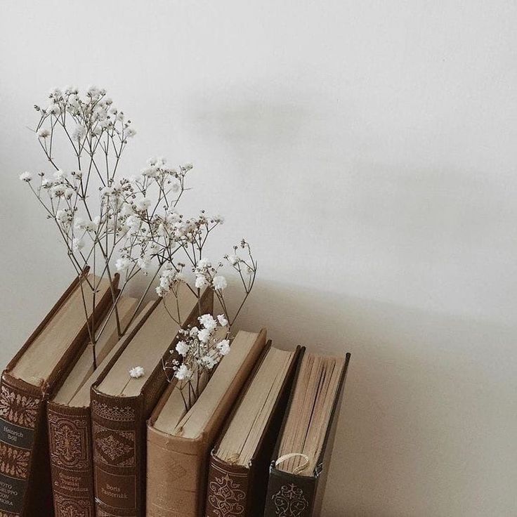 four books with flowers in them sitting on a table