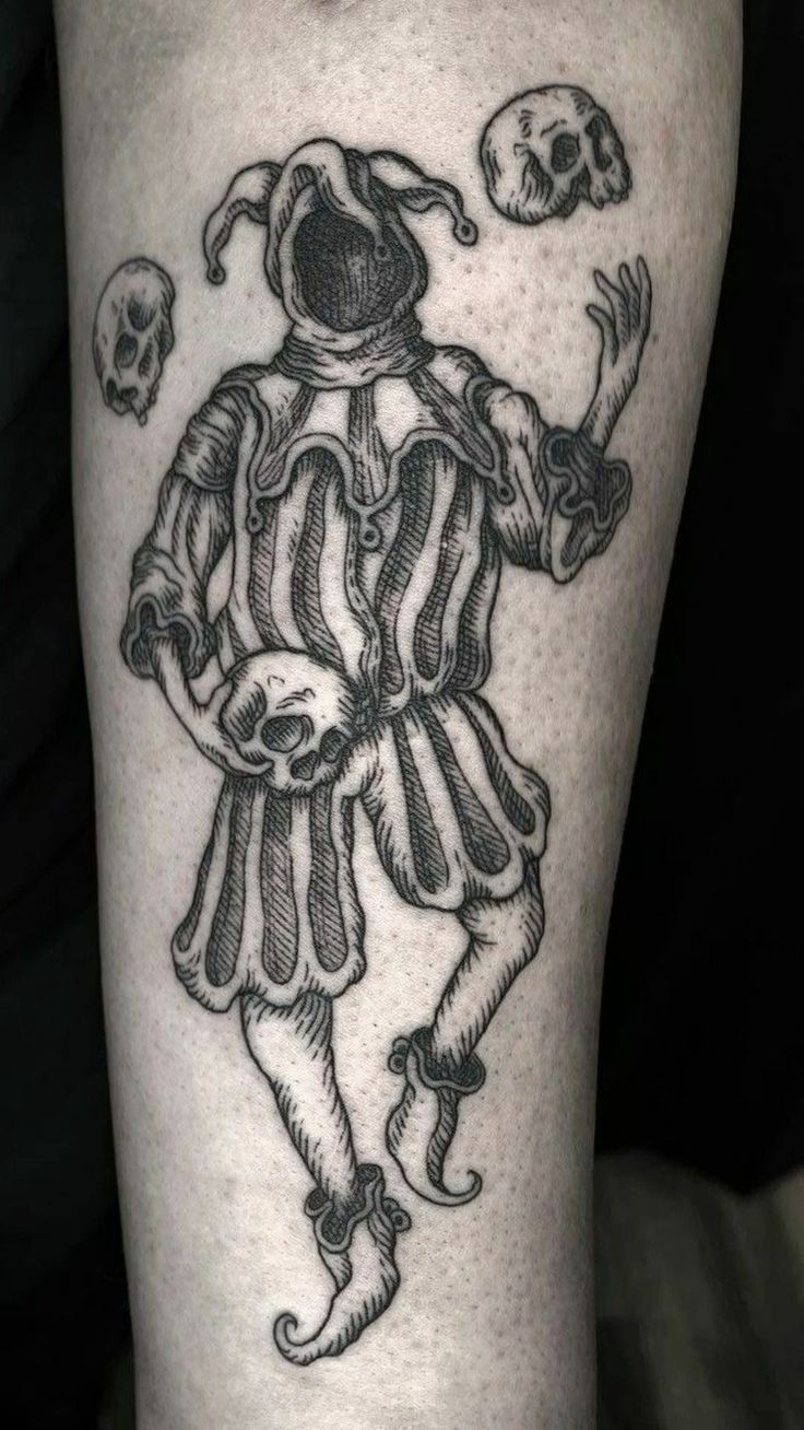 a black and white image of a man with a skull on his leg