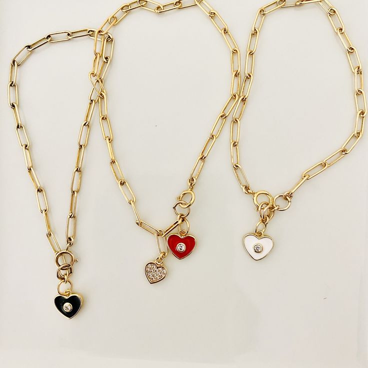 Loving these new heart charm bracelets. Something about them reminds me of the playfulness of childhood, but with an updated elegant (and adult) twist. These enamel charms are available in red, light pink, white, and black, and are all accented with a cubic zirconia. Charm also available in a cubic zirconia heart. If you like the looks of how some are styled in the pictures with multiple charms, please contact me for a customizable bracelet. Otherwise, each bracelet comes with 1 charm. Charms ar Trendy White Heart Charm Bracelet, Red Heart Charm Bracelet For Friendship, Red Heart Charm Jewelry For Friendship, Heart-shaped Charm Bracelet With Dangling Charms For Valentine's Day, Heart-shaped Friendship Charm Necklaces, Trendy Red Heart Bracelet As A Gift, Trendy Red Heart Bracelet As Gift, Trendy Red Heart Bracelet For Gift, Heart-shaped Jewelry With Removable Charms For Valentine's Day