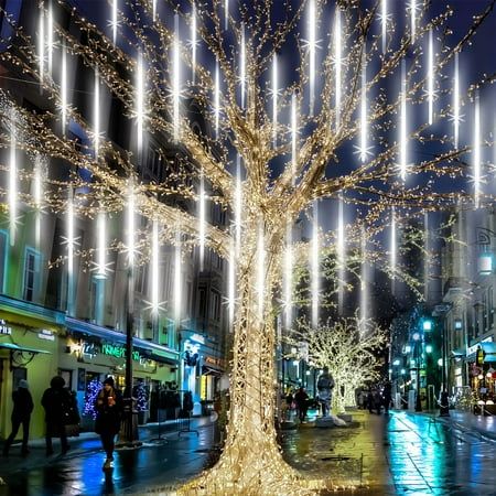 a lighted tree on a city street at night