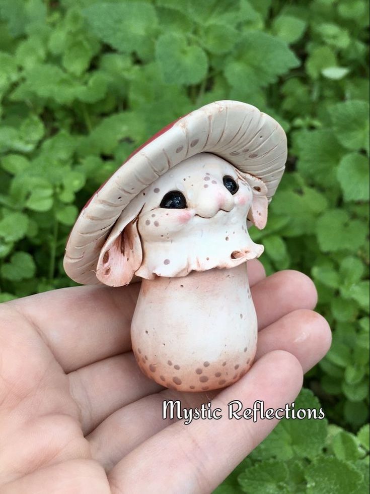 a small mushroom with a hat on it's head is held in someones hand