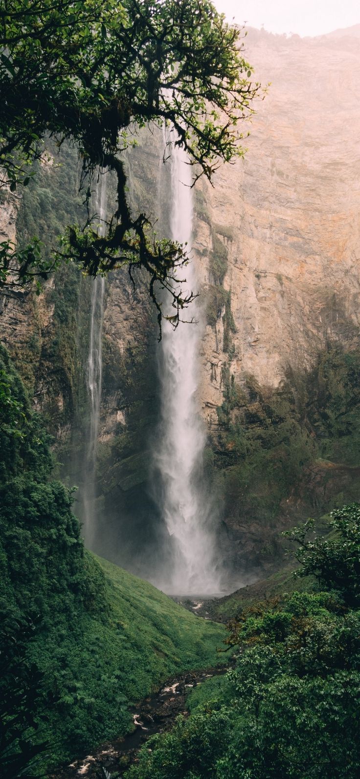 a large waterfall is in the middle of some trees