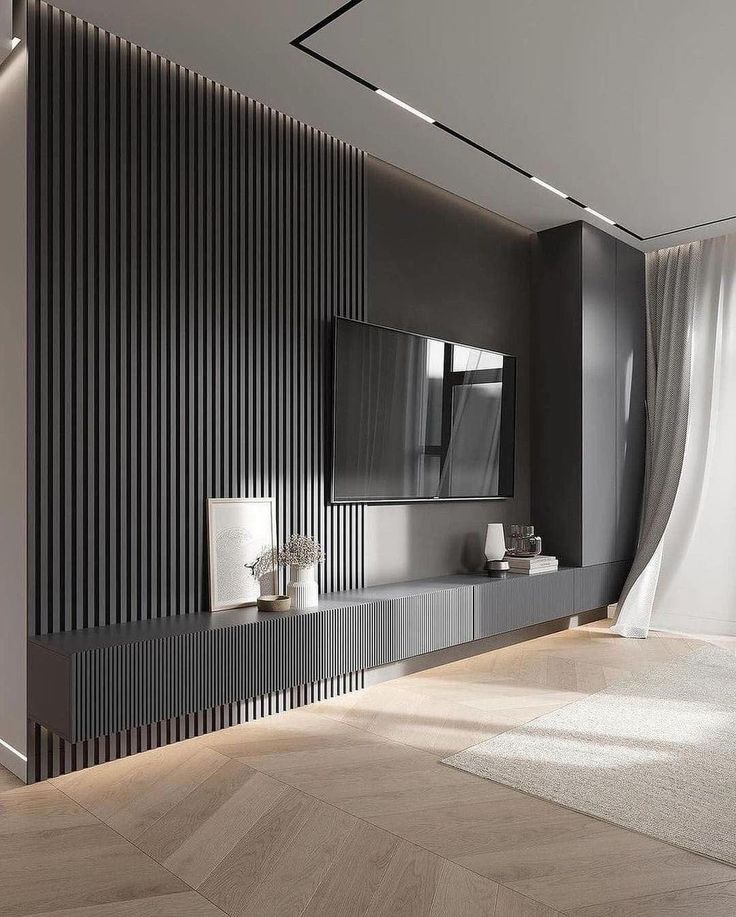 a modern living room with black and white walls, wood flooring and an entertainment center