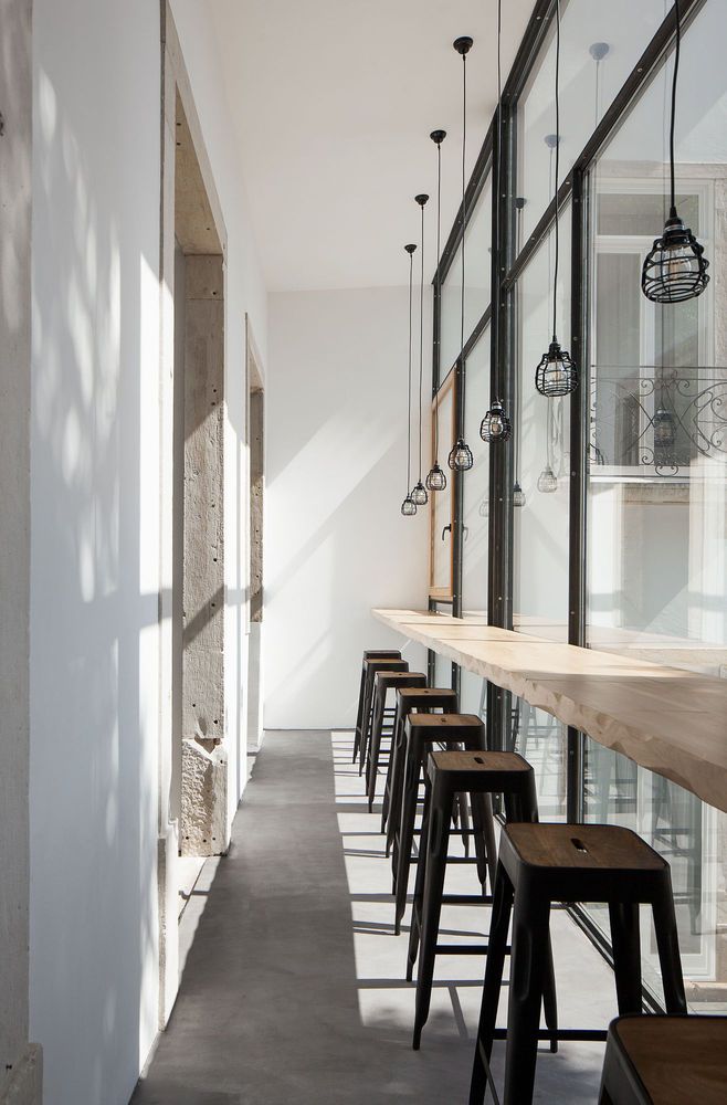 an empty restaurant with lots of stools and tables in front of the glass windows