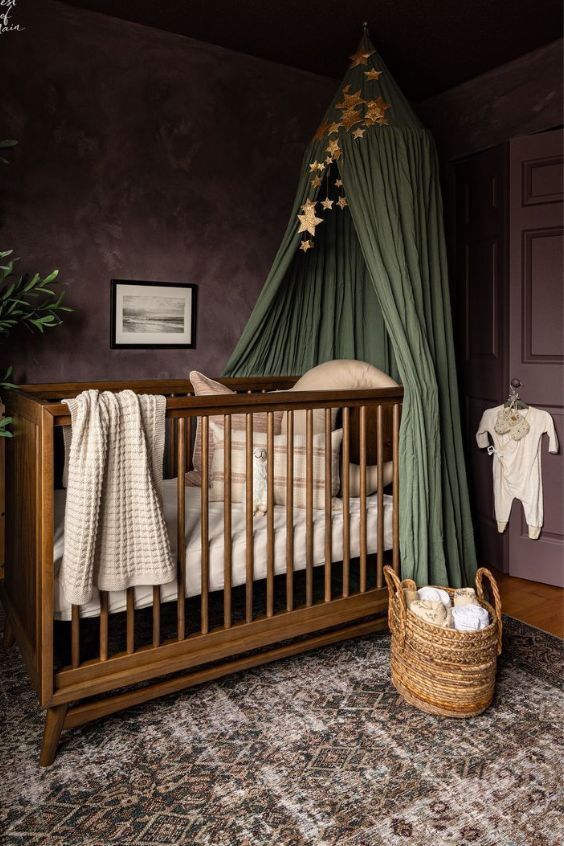 a baby's crib in a room with purple walls and green drapes