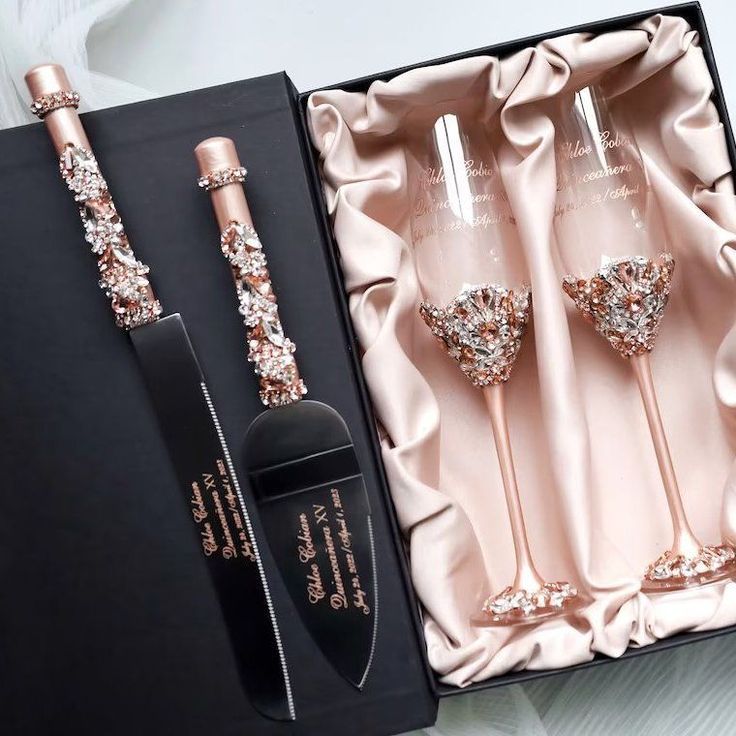 three champagne flutes in a gift box next to a knife and fork with swarozak on it