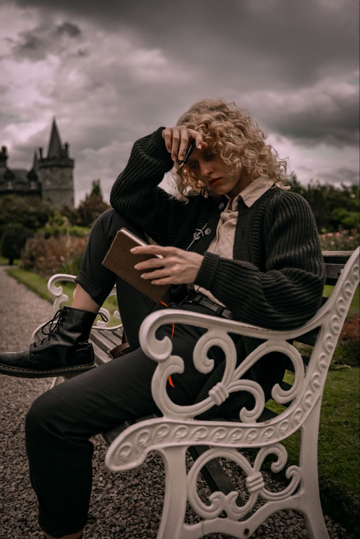 a woman sitting on a bench reading a book