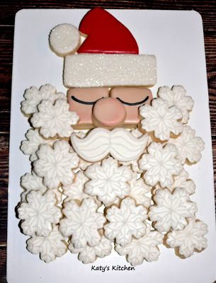 a white plate topped with cookies covered in frosting and santa clause hat on top of it